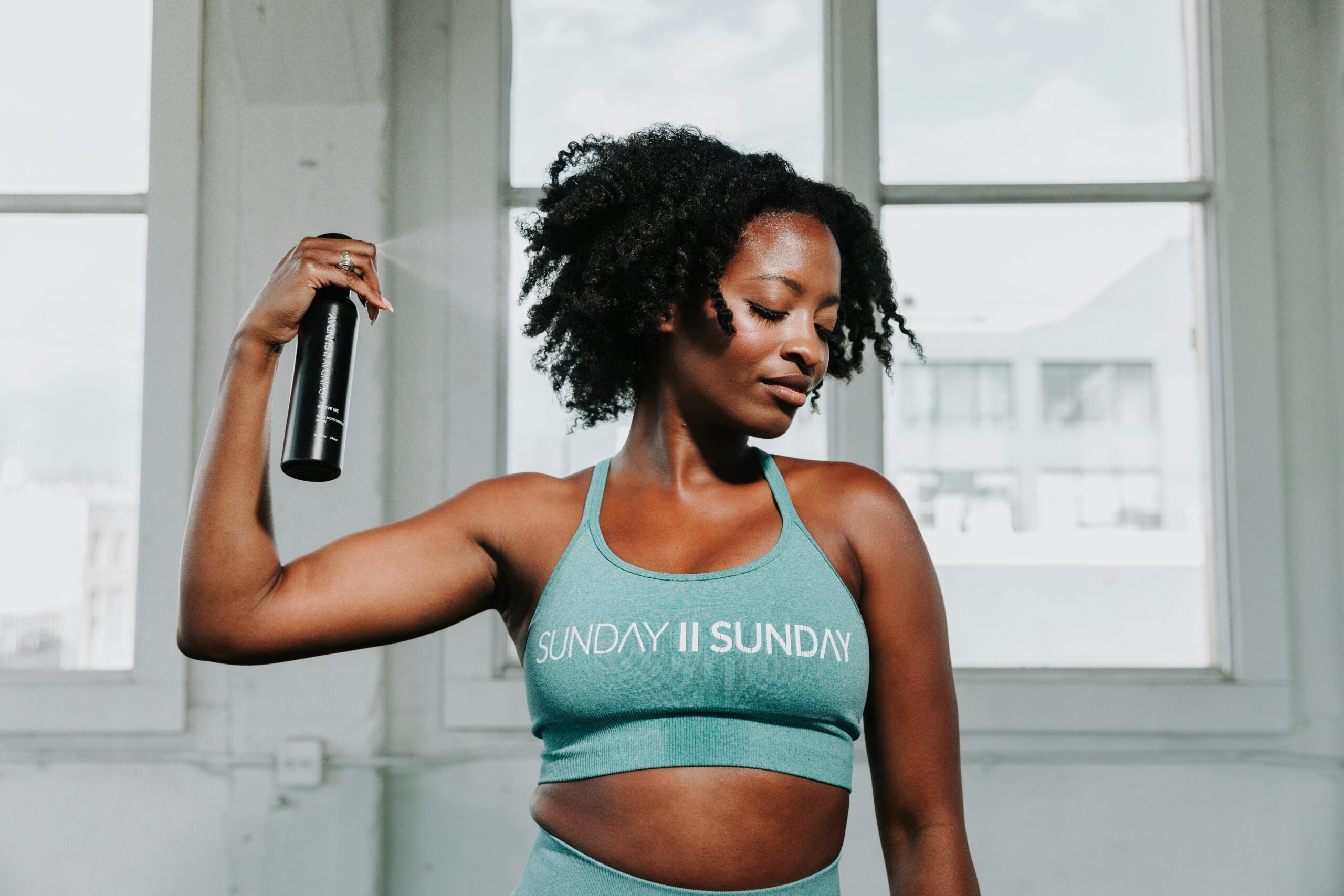 Closeup shot of colorful resistance bands stretched across a wooden surface next to a water bottle.