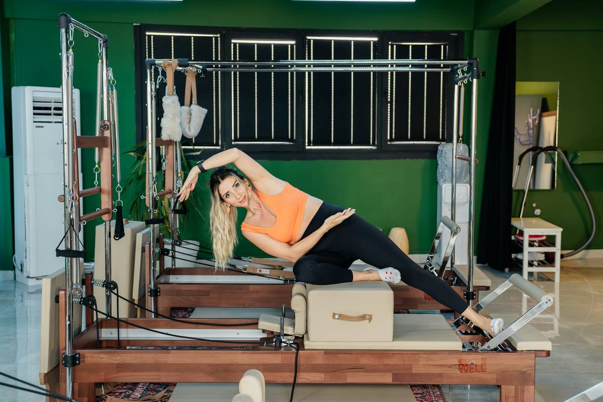 A group of women practicing pilates in a bright studio