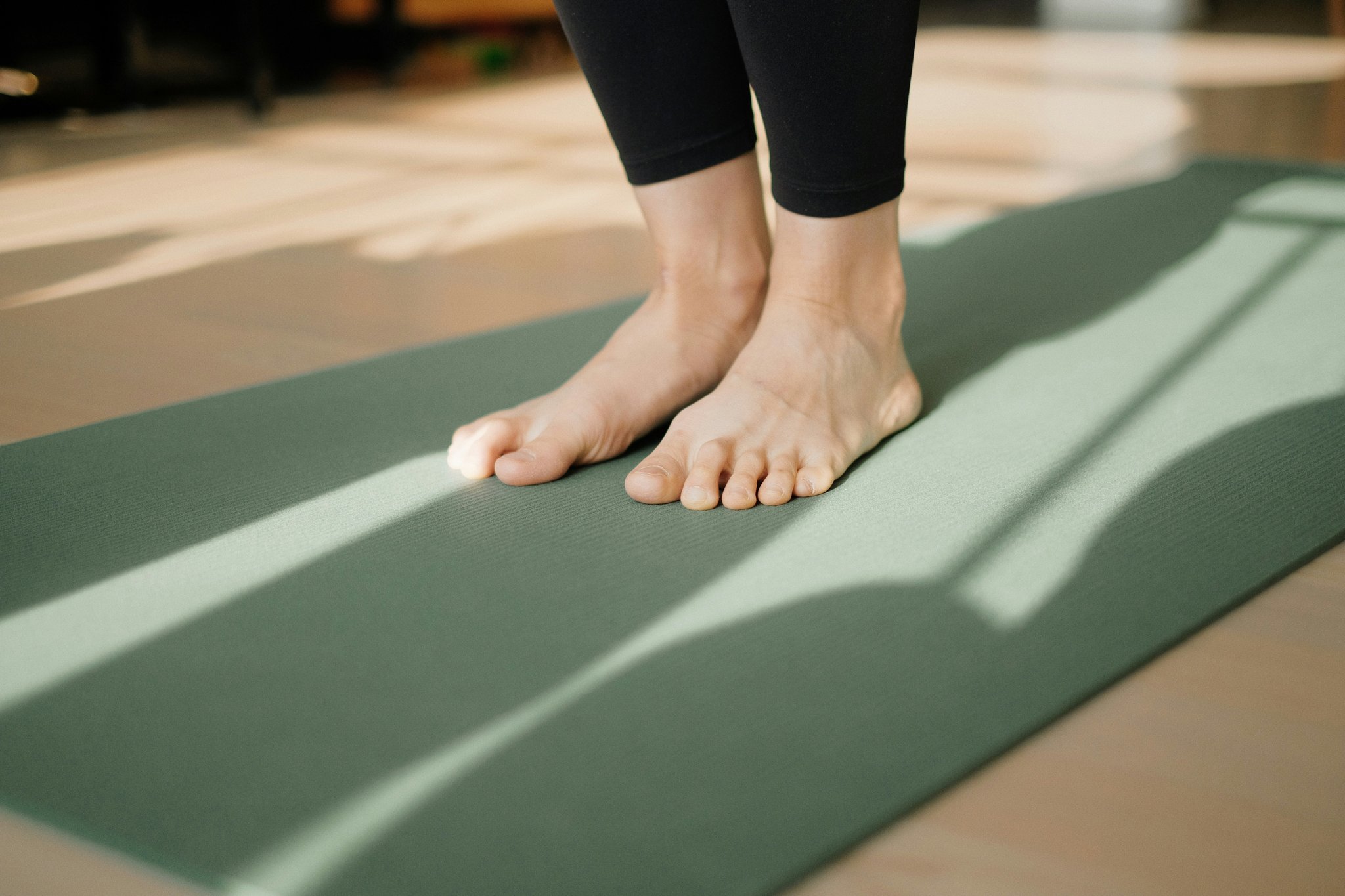 A woman performing a plank variation as part of her lean pilates workout