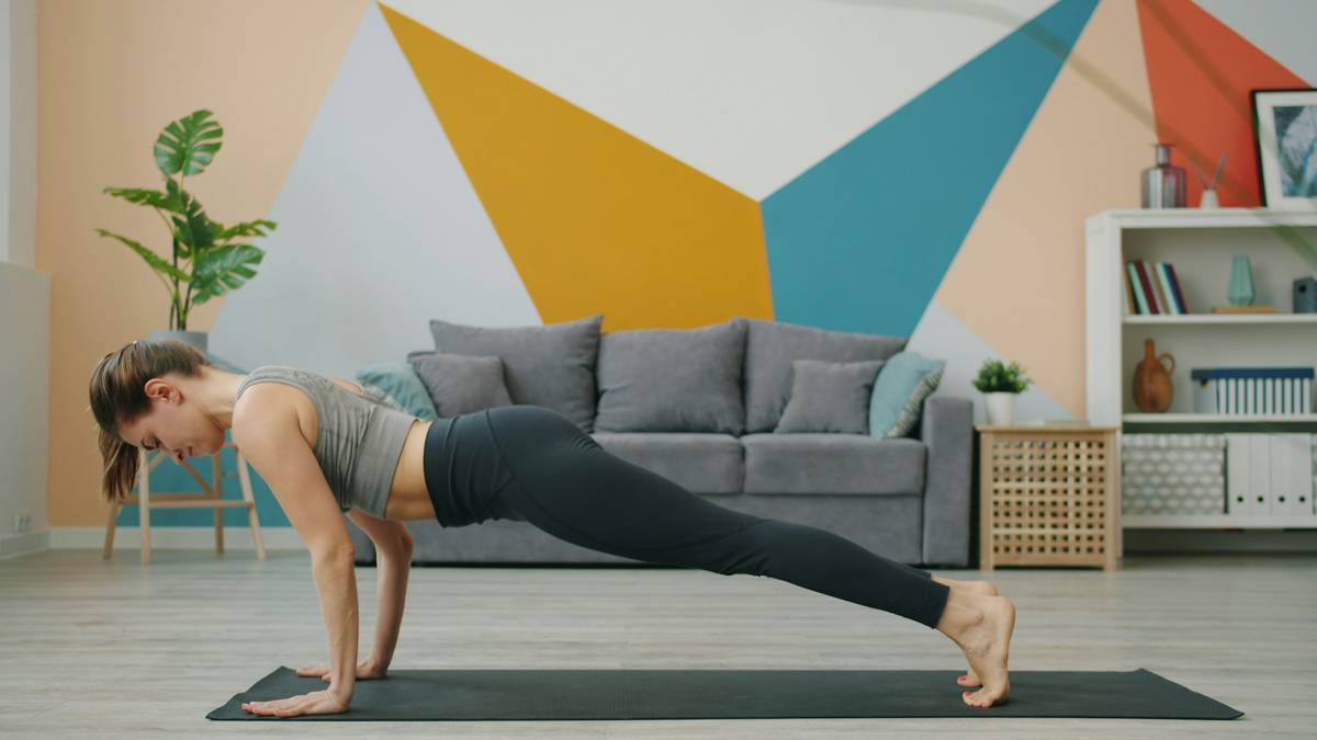 A woman performing a pilates move on a mat